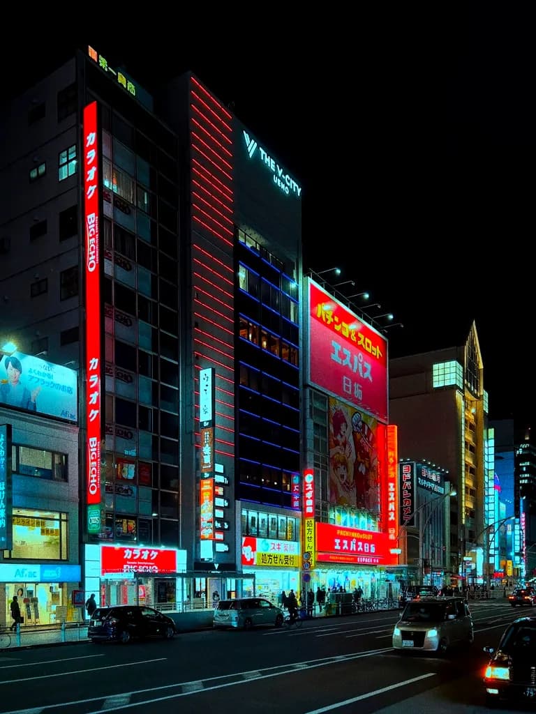 Building facades covered in glowing signs against a black sky