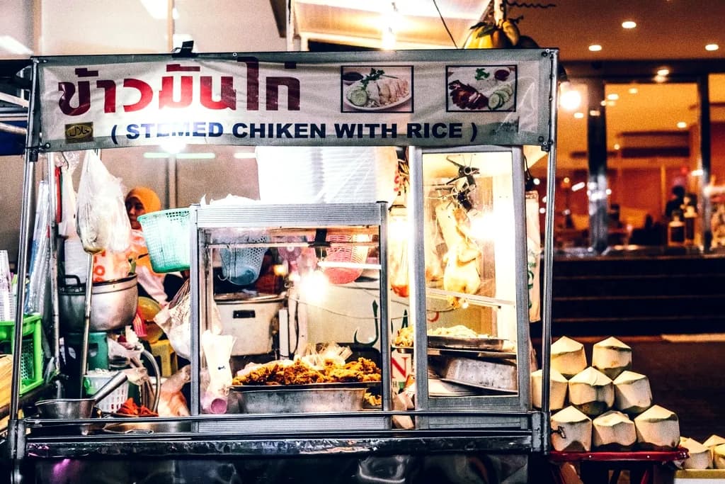 A late-night street food cart with a lit menu board