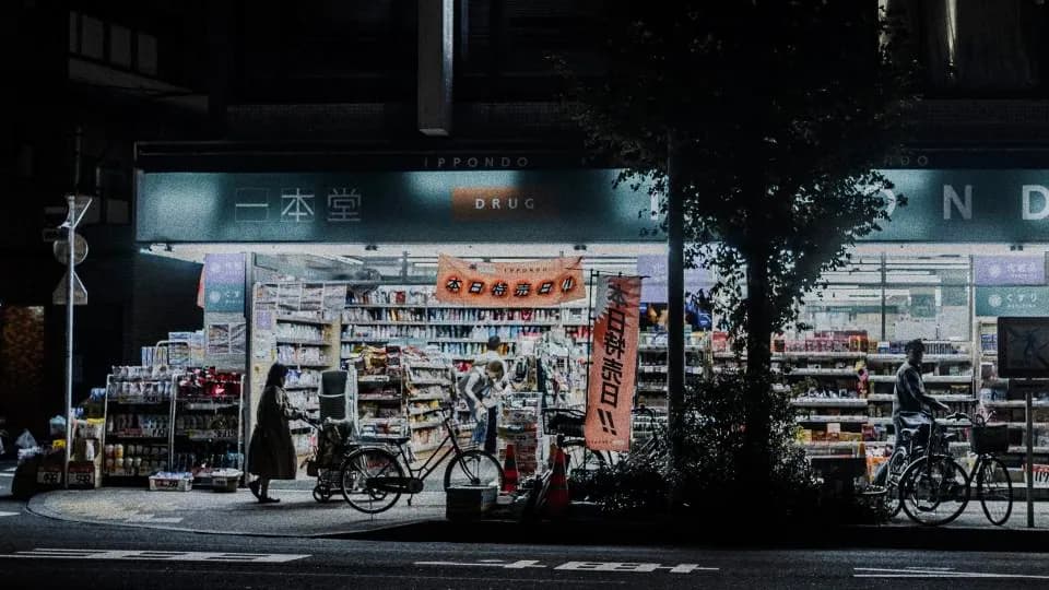 A brightly lit convenience store at night with bicycles parked outside